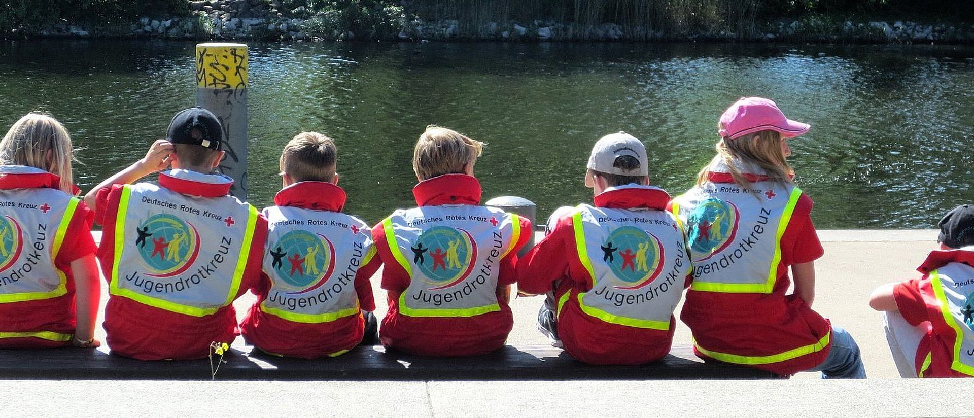 Die Kinder sitzen am Ufer